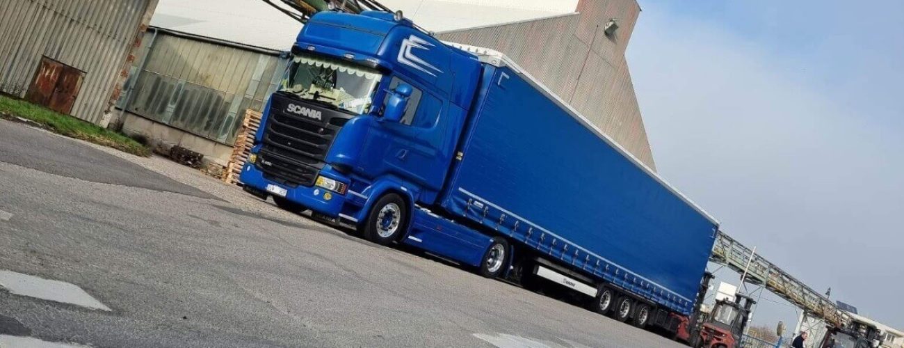 A truck parked within the areal of industry parking lot.